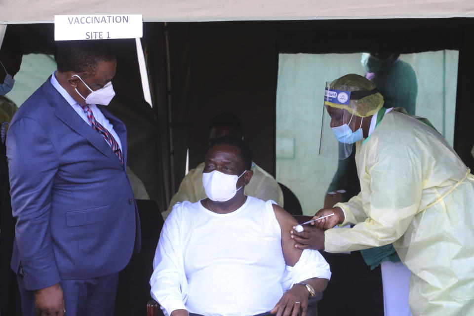 Zimbabwean President Emmerson Mnangagwa, centre, receives his shot of the Chinese Sinovac COVID-19 vaccine in Victoria Falls, Wednesday March 24, 2021. Mnangagwa got his jab in the resort town of Victoria Falls, in a bid to promote tourism and launch the second phase of the countrys vaccination drive.(AP Photo/STR)