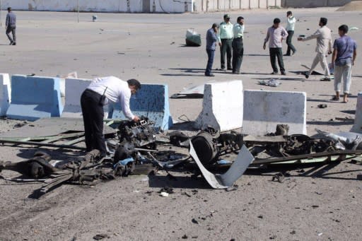 A detective inspects the wreckage of the car bomb detonated in Thurday's attack on police heaquarters in the port city of Chabahar in southeastern Iran