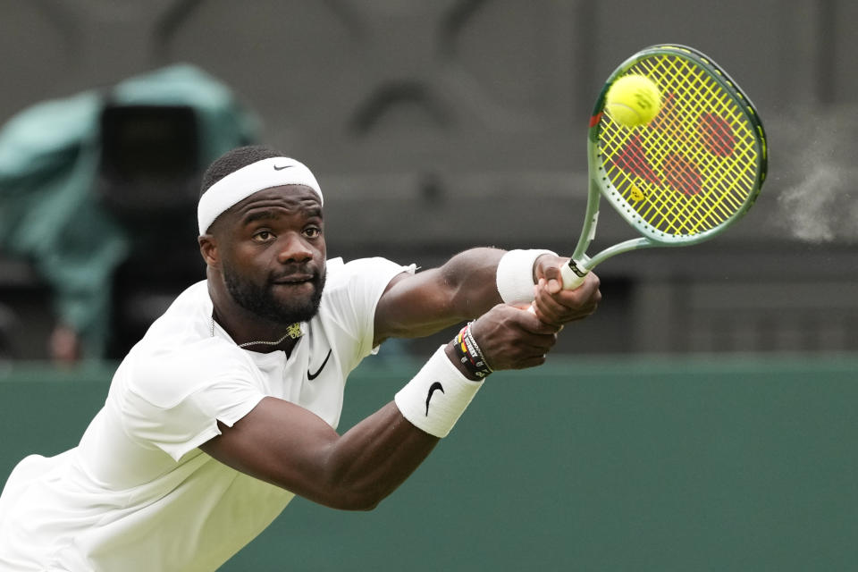 Francis Tiafoe of the United States plays a backhand return to Spain's Carlos Alcaraz during their third round match at the Wimbledon tennis championships in London, Friday, July 5, 2024. (AP Photo/Alberto Pezzali)