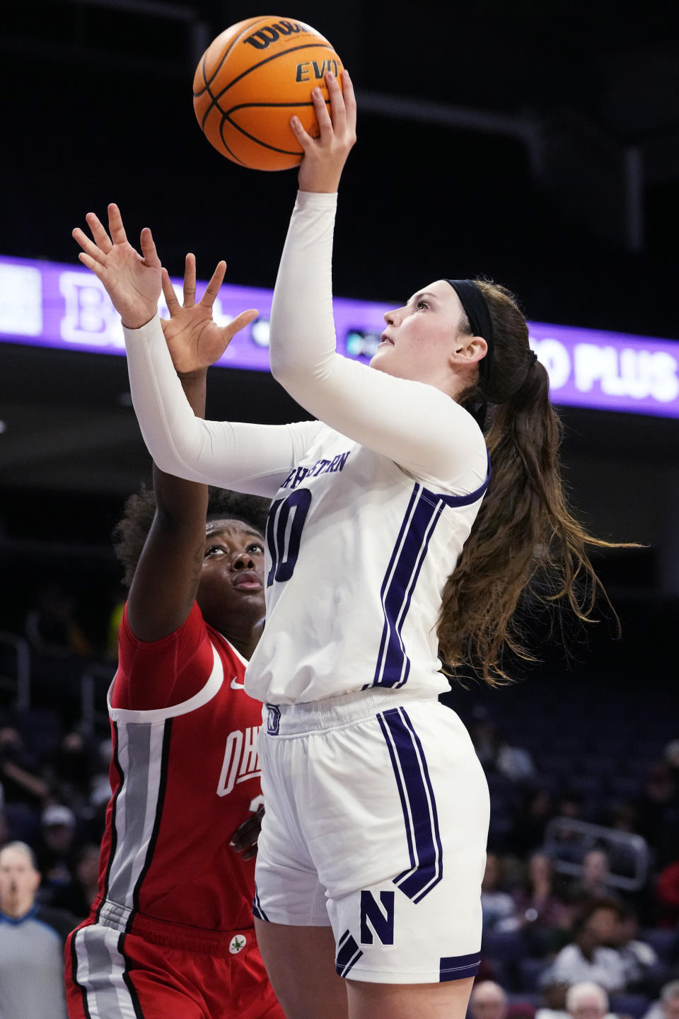 Northwestern forward Caileigh Walsh, right, goes up for a shot against Ohio State forward Eboni Walker during the second half of an NCAA college basketball game Wednesday, Dec. 28, 2022, in Evanston, Ill. Ohio State won 81-48. (AP Photo/Nam Y. Huh)