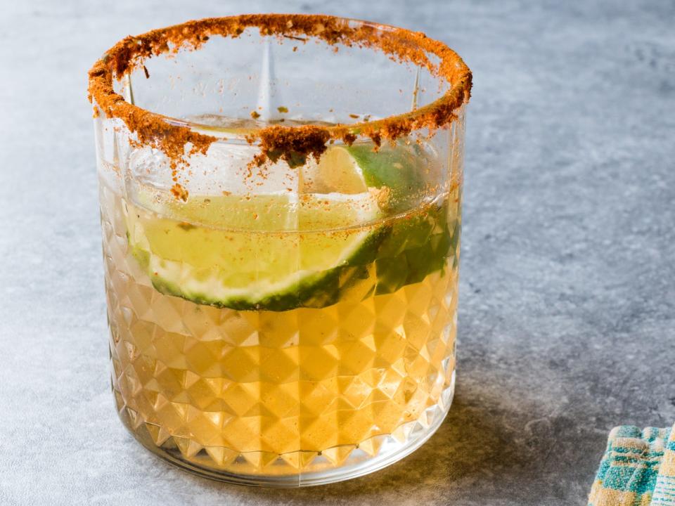 a spicy mezcal margarita cocktail on a gray surface