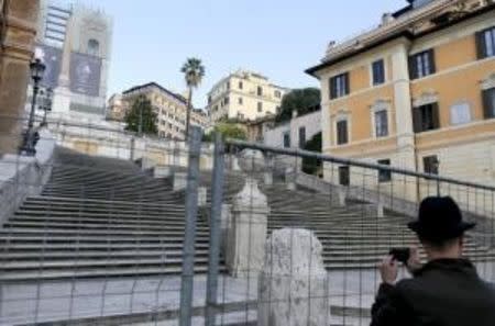 A man takes a picture through a barrier at the bottom of the Spanish Steps in Rome, Italy October 7, 2015. REUTERS/Alessandro Bianchiâ€¨