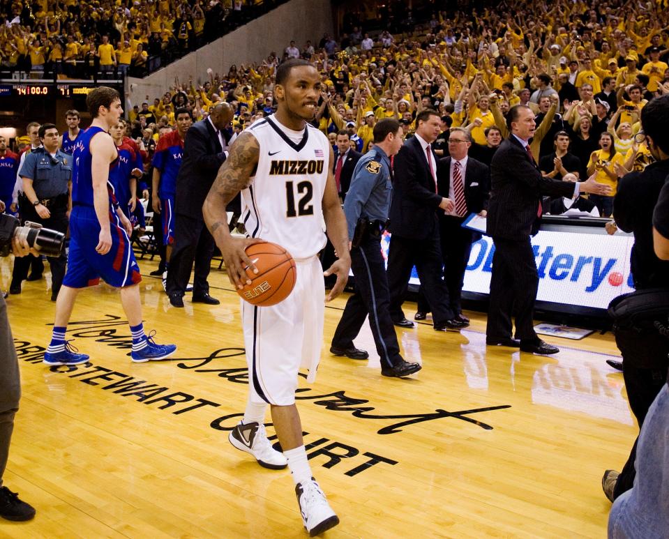 Missouri's Marcus Denmon, center, walks off the court with the ball after Missouri defeated Kansas 74-71 in an NCAA college basketball game on Saturday, Feb. 4, 2012, in Columbia, Mo. Missouri won the game 74-71.