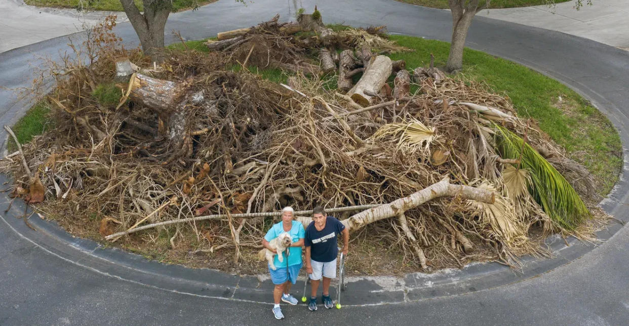 George and Lori Melton live near this pile of storm debris in Village des Pins, in south Sarasota.