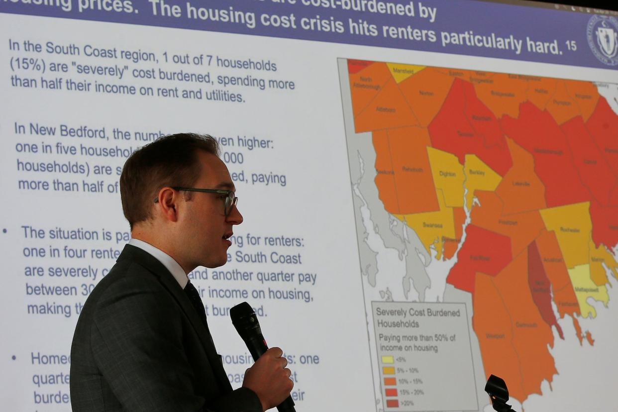 Eric Shupin, Chief of Policy Executive Office of Housing and Livable Communities speaks at one of the fourteen regional listening sessions held at UMass Dartmouth. Behind him a chart outlining the impact affordable housing has had on the SouthCoast.