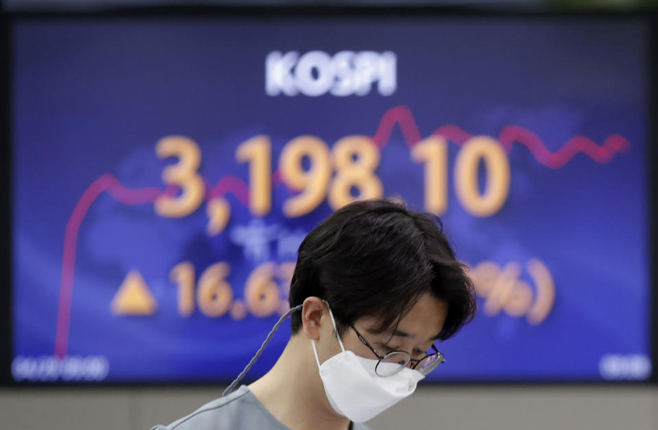 A currency trader walks near the screen showing the Korea Composite Stock Price Index (KOSPI) at the foreign exchange dealing room in Seoul, South Korea, Thursday, April 29, 2021. Asian shares rose Thursday and U.S. futures also were higher after President Joe Biden delivered a speech to Congress that outlined ambitious plans for jobs creating spending on early education, child care and other public services. (AP Photo/Lee Jin-man)