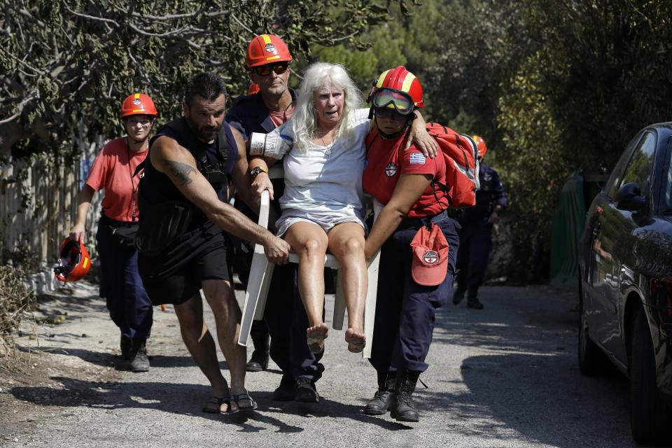 <p>Members of a rescue team carry an injured woman in Mati, east of Athens, Wednesday, July 25, 2018. (Photo: Thanassis Stavrakis/AP) </p>