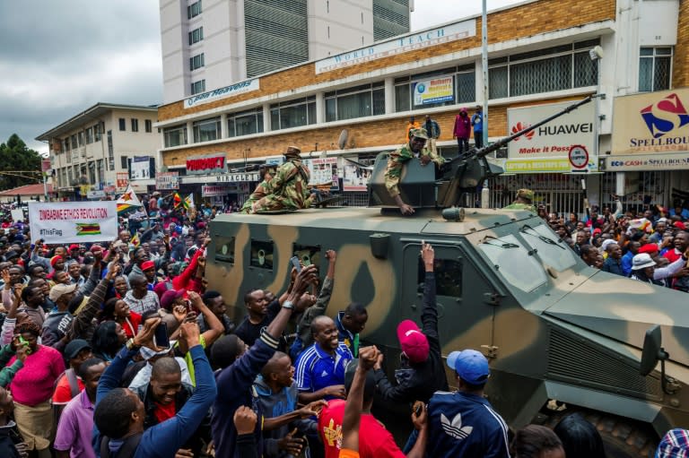 People cheer a Zimbabwe Defense Force military vehicle during a demonstration demanding the resignation of Robert Mugabe