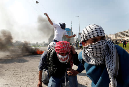Palestinian protesters hurl stones at Israeli troops during clashes near the Jewish settlement of Beit El, in the Israeli-occupied West Bank March 20, 2019. REUTERS/Mohamad Torokman