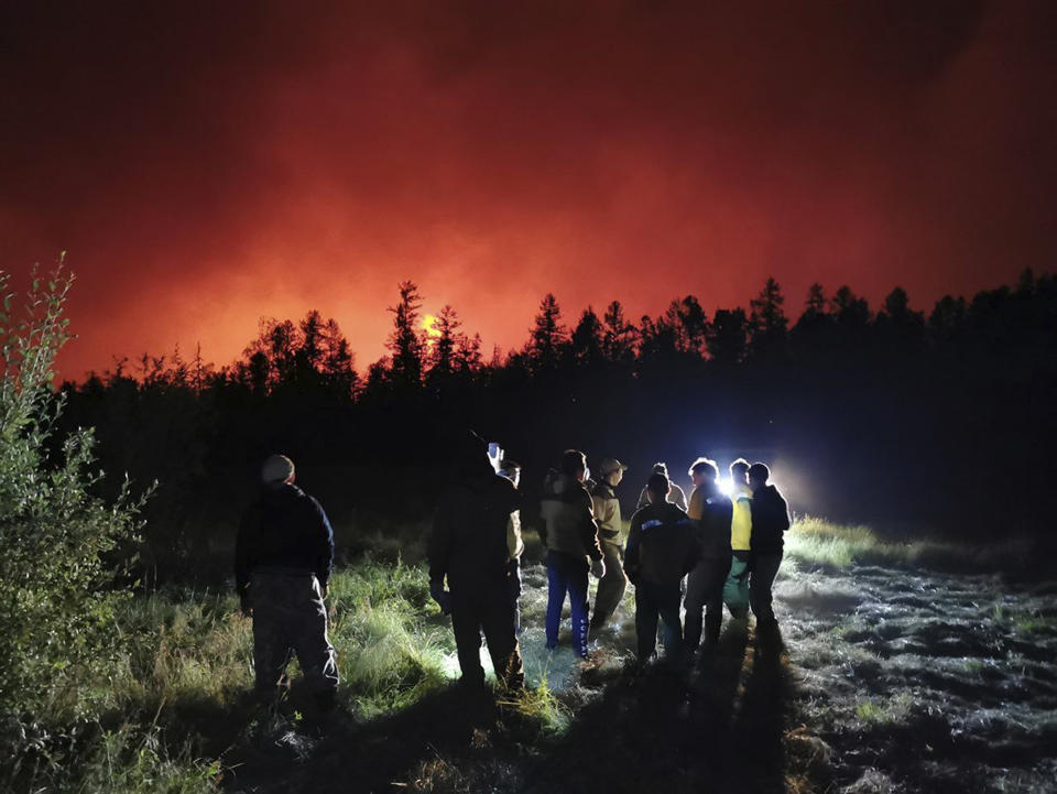 FILE - Firefighters and volunteers have a briefing as they work at the scene of forest fire at Gorny Ulus area west of Yakutsk, in Russia, Saturday, Aug. 7, 2021. The U.N. weather agency has certified a 38-degree Celsius (100.4 Fahrenheit) reading in the Russian town of Verkhoyansk last year as the highest temperature ever recorded in the Arctic. The World Meteorological Organization said the temperature "more befitting the Mediterranean than the Arctic" was recorded in June 2020 during a heat wave that swept across Siberia and stretched north of the Arctic Circle. Average temperatures were up to 10 degrees Celsius more than usual in Arctic Siberia. (AP Photo/Ivan Nikiforov, File)