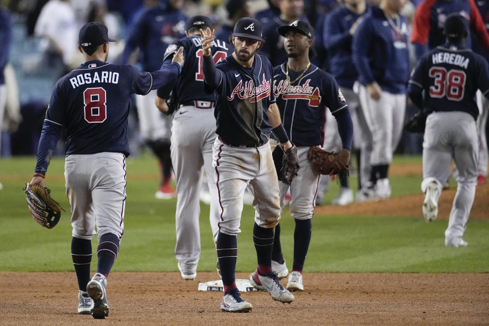 Atlanta Braves left fielder Eddie Rosario (8) is congratulated by teammates after Game 4 of baseball's National League Championship Series Wednesday, Oct. 20, 2021, in Los Angeles. The Braves defeated the Dodgers 9-2 and lead the series 3-1 games. (AP Photo/Marcio Jose Sanchez)