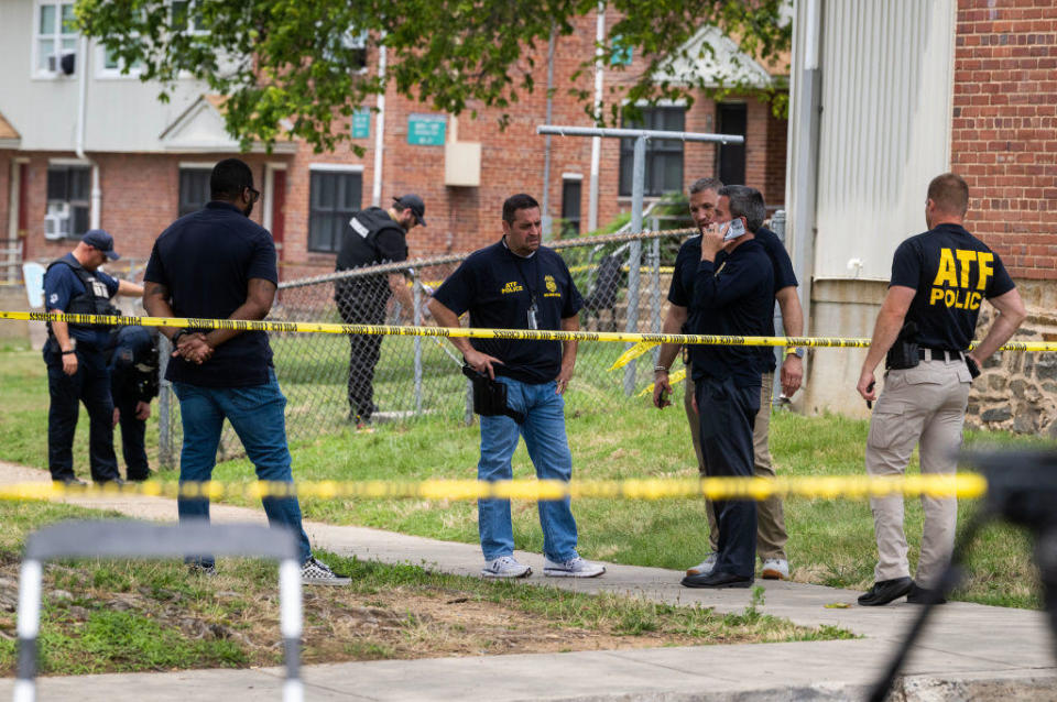 Authorities search for evidence at the scene of a mass shooting that left 2 dead and 28 wounded in Baltimore, Maryland. / Credit: Bill O'Leary/The Washington Post via Getty Images