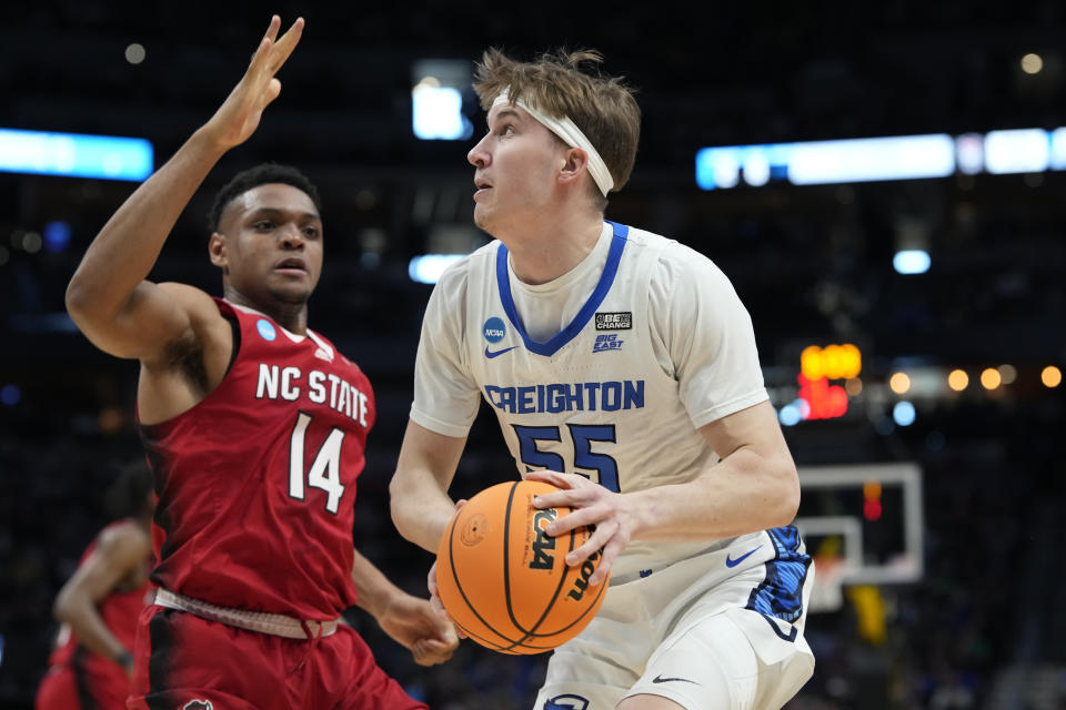 Creighton guard Baylor Scheierman, right, drives to the basket past North Carolina State guard Casey Morsell in the second half of a first-round college basketball game in the men's NCAA Tournament Friday, March 17, 2023, in Denver. (AP Photo/David Zalubowski)