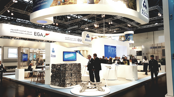 Conference exhibit showing bundles of recycled aluminum at an Alcoa booth.