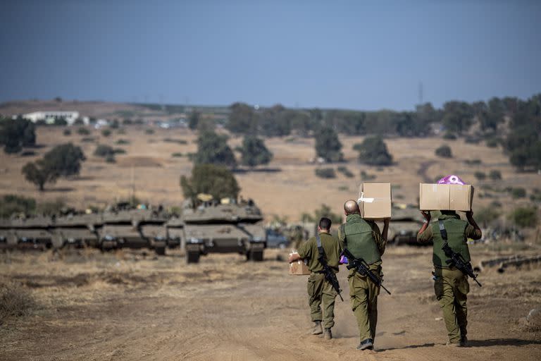Soldados israelíes transportan suministros cerca de la frontera con Líbano el martes 10 de octubre de 2023. (AP/Gil Eliyahu)
