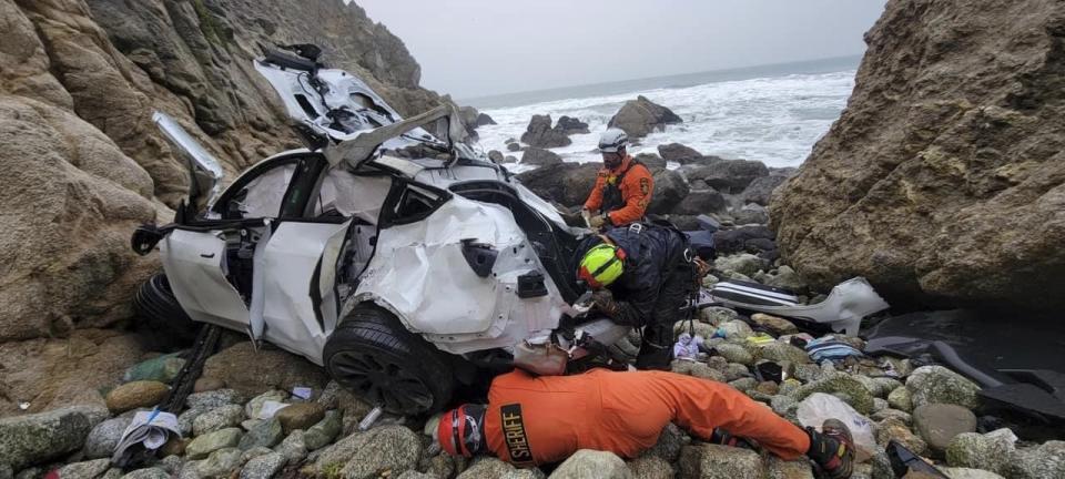 This photo provided by the San Mateo County Sheriff's Office shows emergency personnel responding to a vehicle over the side of Highway 1 on Sunday, Jan. 1, 2023, in San Mateo County, Calif. The driver of the car that plunged off a cliff in Northern California, seriously wounding two children and a second adult after the 250-foot drop, was arrested on suspicion of attempted murder and child abuse, the California Highway Patrol said Tuesday, Jan. 3. (Sgt. Brian Moore/San Mateo County Sheriff's Office via AP)