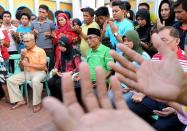 Self-proclaimed Sultan of Sulu Jamalul Kiram (C) and his supporters pray at a mosque in Manila on March 6, 2013 for his followers battling Malaysian forces in Sabah