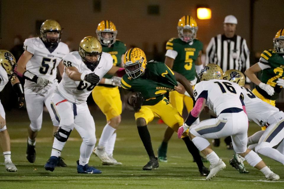 Grosse Pointe North's Jayden Holyfield is tackled by Grosse Pointe South defenders during first-half action on Friday, Oct. 21, 2022.