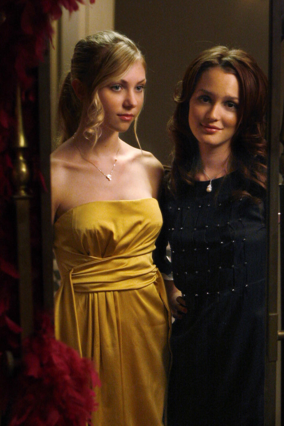 Jenny standing next to another girl and looking in a mirror in a scene from "Gossip Girl"