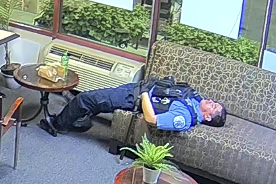 FILE - In this file still image taken from security video released by the Congressman Bobby Rush's Campaign Office, a Chicago police officer lies on a couch inside Rush's burglarized congressional campaign office in Chicago on Sunday, May 31, 2020. Chicago Police suspended several officers captured on video during 2020's widespread unrest who were lounging, and apparently even sleeping, inside a burglarized congressional campaign office as people citywide vandalized and stole from businesses, a police union official said, Thursday, Jan. 14, 2021. (Congressman Bobby Rush's Campaign Office via AP, File)