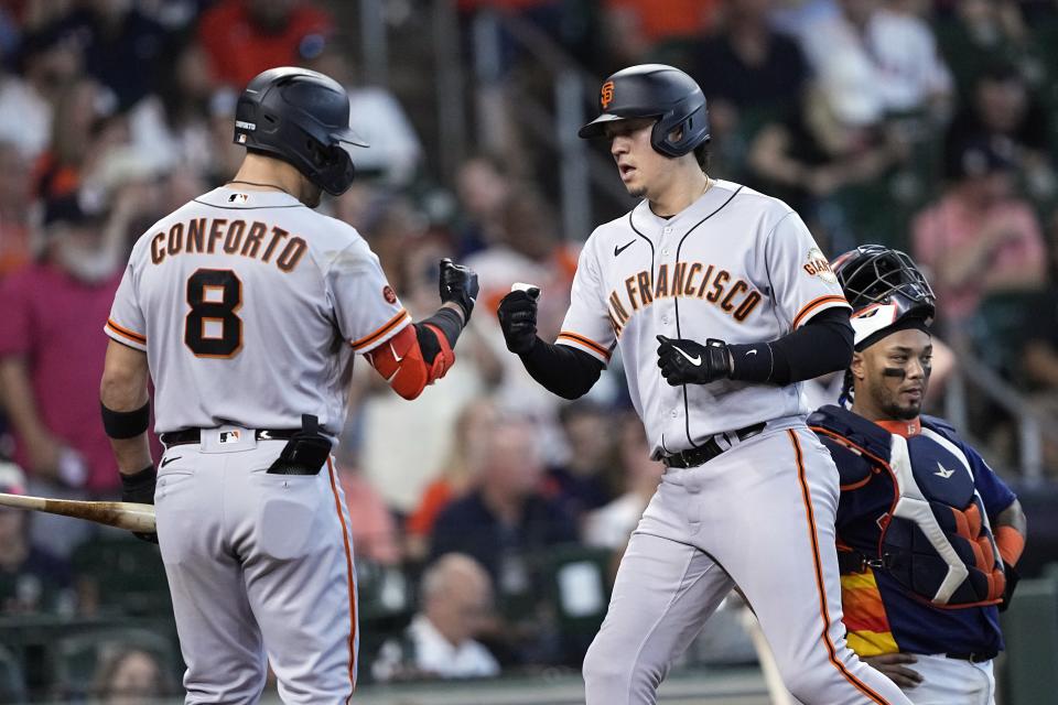 San Francisco Giants' Wilmer Flores, center, celebrates with Michael Conforto (8) after hitting a home run as Houston Astros catcher Martin Maldonado kneels behind home plate during the ninth inning of a baseball game Wednesday, May 3, 2023, in Houston. (AP Photo/David J. Phillip)