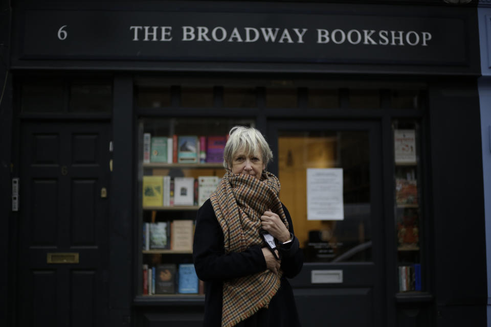 Jane Howe, the owner of the Broadway Bookshop poses for a portrait outside her shop which is temporarily closed for in-store browsing but open for customers to purchase books online and collect them from outside the shop door, during England's second coronavirus lockdown, on Broadway Market in Hackney, east London, Tuesday, Nov. 17, 2020. Small businesses all over the world are struggling to cope as the coronavirus forces changes in consumer habits, but the U.K. also faces uncertainty of the Brexit split from Europe. (AP Photo/Matt Dunham)