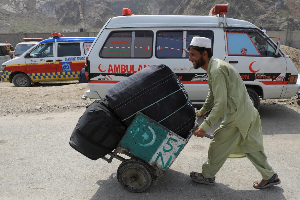 A man pushes a hand trolley carrying his belongings as he passes through the main Afghanistan-Pakistan land border crossing in Torkham, Pakistan on September 15, 2023. (REUTERS - image credit)