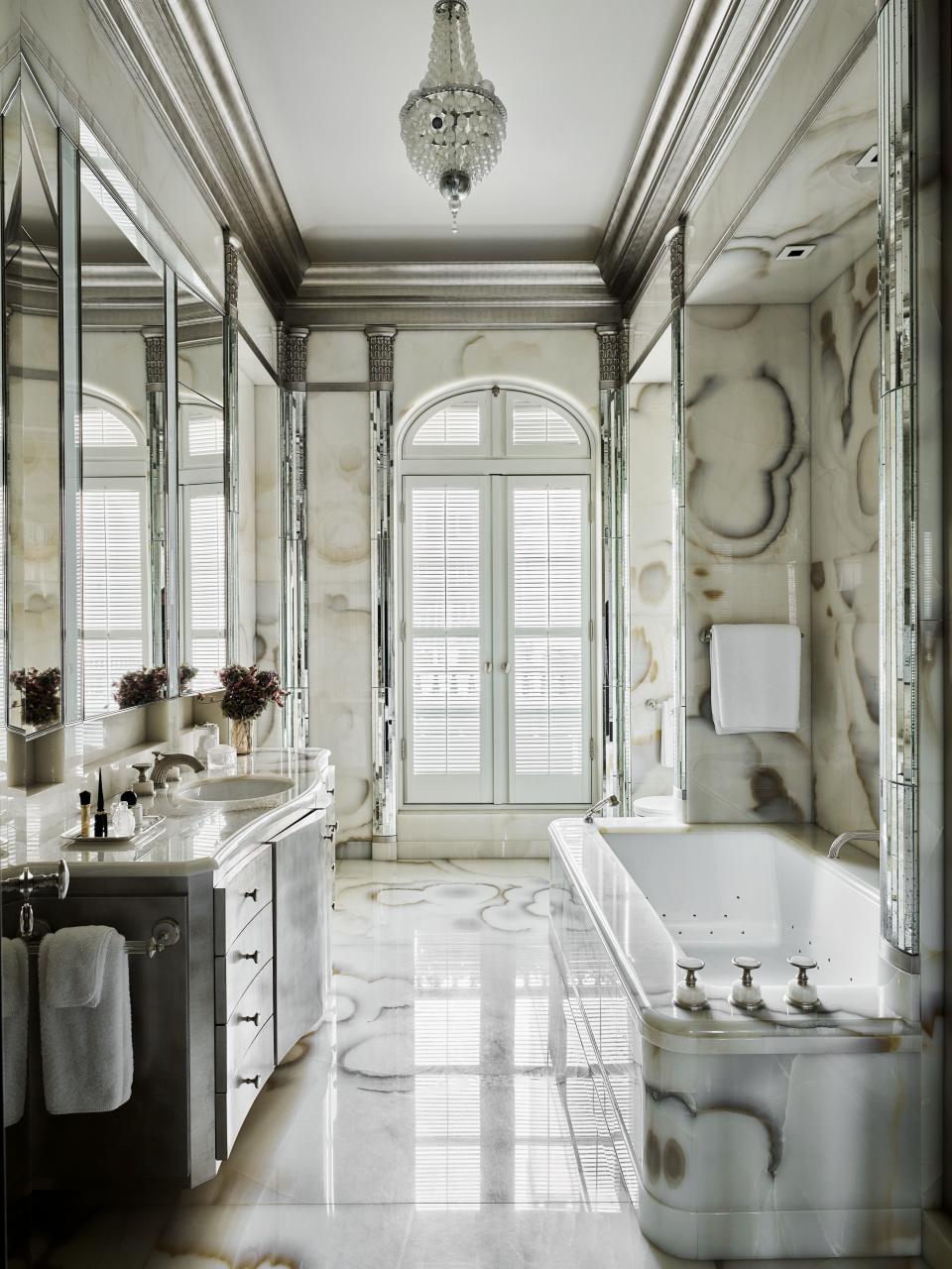 One of the house’s new spaces is the wife’s bath, which marino clad in white cloud onyx and striped with mirrored pilasters; the vanity is surfaced with silver leaf.