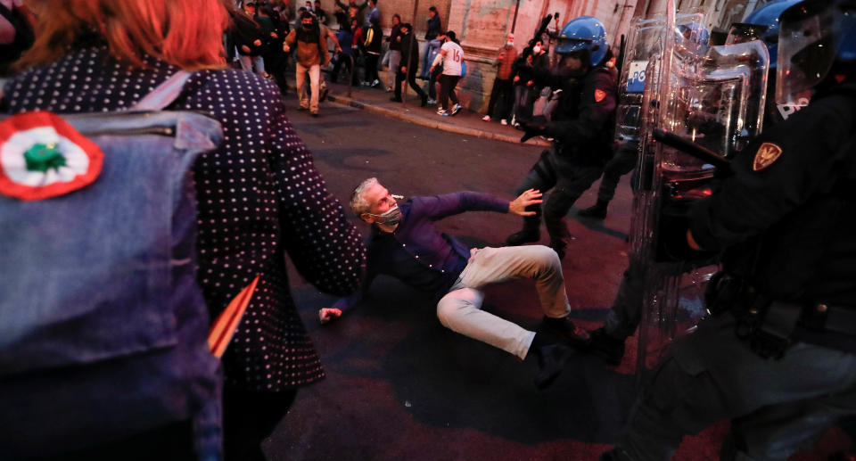 Police officers approach a demonstrator protesting against the government's introduction of the 