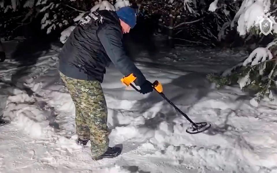 Investigators work at the site where Illia Kyva was killed in a cottage village near Moscow, Russia