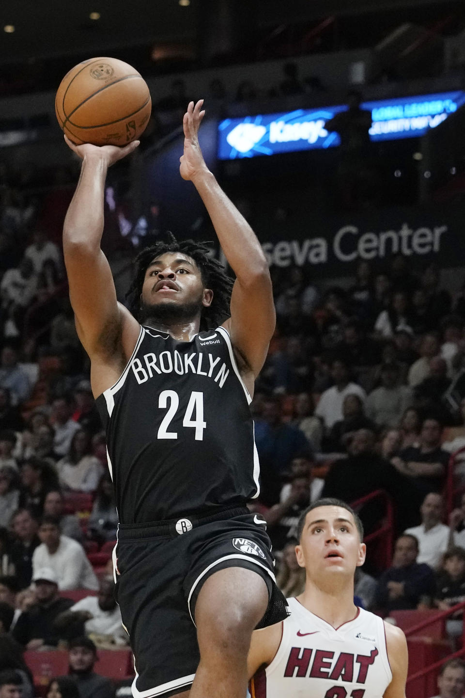 Brooklyn Nets guard Cam Thomas (24) aims a three-point- basket over Miami Heat forward Cole Swider during the second half of an NBA preseason basketball game, Wednesday, Oct. 18, 2023, in Miami. (AP Photo/Marta Lavandier)