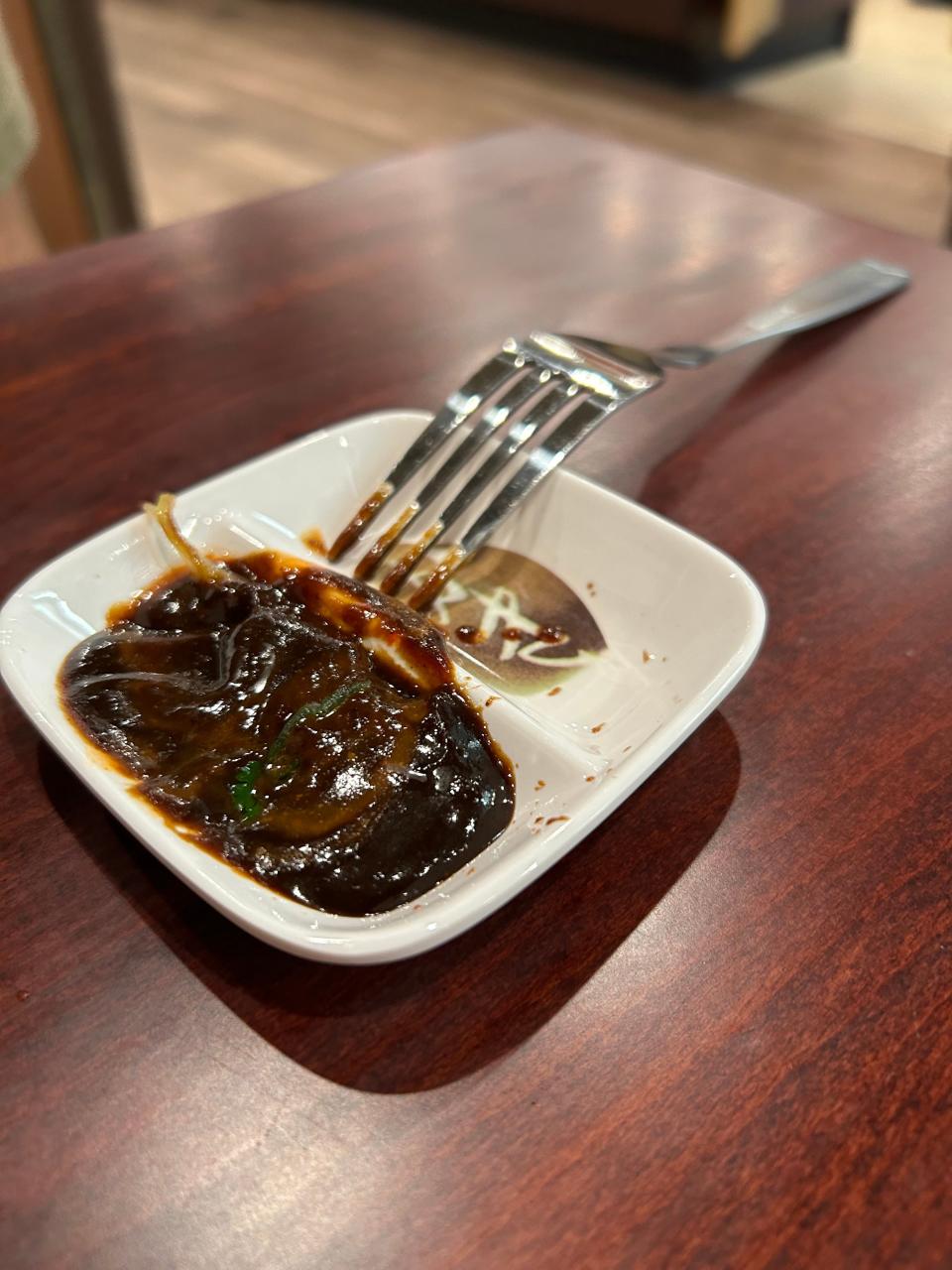 Meat from a pho dish is dipped in a mixture of tangy hoisin sauce and sriracha hot sauce.