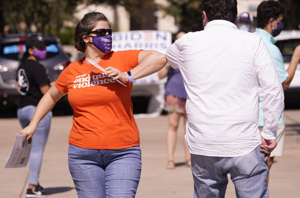 Sarah Mitchell, left, greets Lorenzo Sanchez before a Ridin' With Biden event Sunday, Oct. 11, 2020, in Plano, Texas. Democrats in Texas are pressing Joe Biden to make a harder run at Texas with less than three weeks until Election Day. (AP Photo/LM Otero)