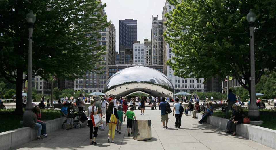 In this Wednesday, June 13, 2012, photo, visitors at Chicago's Millennium Park enjoy the sculpture "Cloud Gate," also known as "The Bean" on Wednesday, June 13, 2012 in Chicago. Millennium Park is one of several free activities/things/places visitors can enjoy in Chicago. (AP Photo/Charles Rex Arbogast)