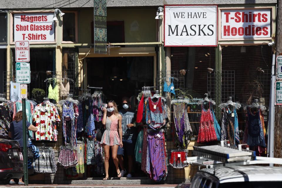 Shoppers leave a clothing shop that now also sells masks to help fight the spread of the coronavirus, Thursday, July 30, 2020, in Portland, Maine. State officials reported more cases of COVID-19. (AP Photo/Robert F. Bukaty)