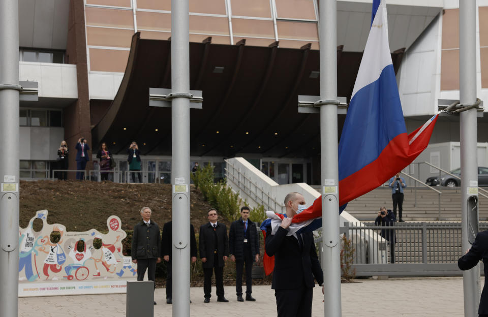 Employees of the Council of Europe remove the Russian flag from the Council of Europe building, Wednesday, March 16, 2022 in Strasbourg. The Council of Europe expelled Russia from the continent's foremost human rights body in an unprecedented move over its invasion and war in Ukraine. The 47-nation organization's committee of ministers said in statement that "the Russian Federation ceases to be a member of the Council of Europe as from today, after 26 years of membership." (AP Photo/Jean-Francois Badias)