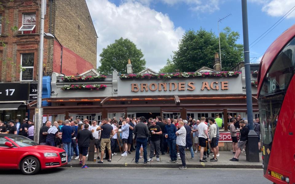 United fans stand outside The Brondes Age pub in Kilburn, north London