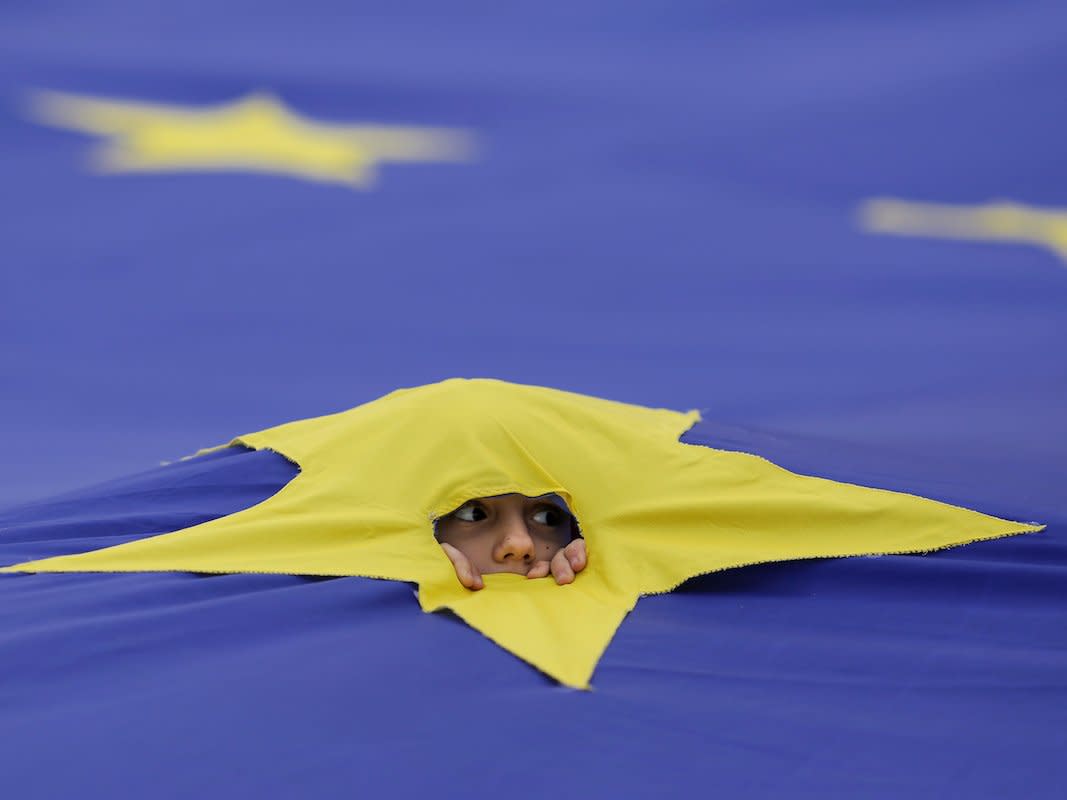 A child peers through a cut made in one of the stars that make up the European Union flag, during a support rally organised to mark the EU's 60th anniversary of the Treaty of Rome in downtown Bucharest, Romania, March 25, 2017.