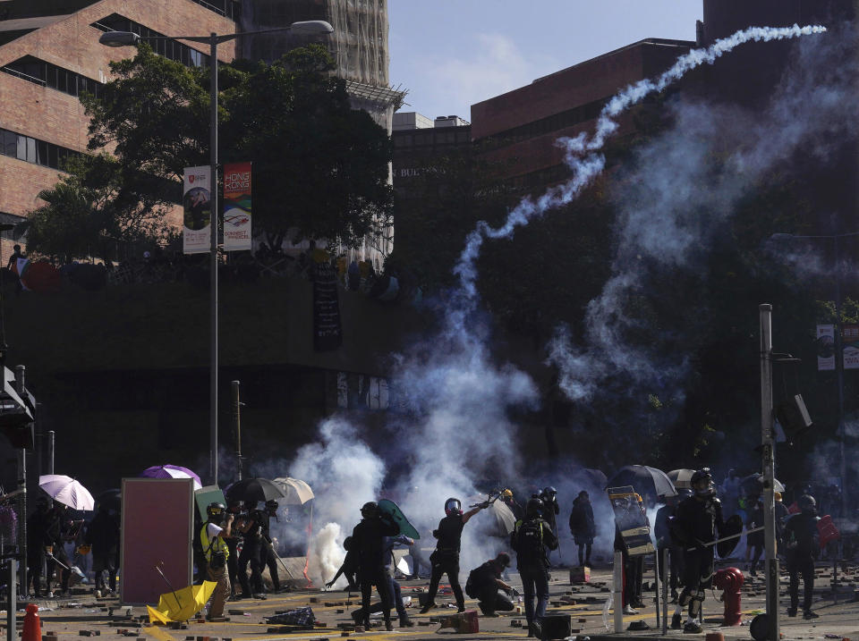 Protestors react as police fire tear gas at Hong Kong Polytechnic University in Hong Kong, Sunday, Nov. 17, 2019. (AP Photo/Vincent Yu)