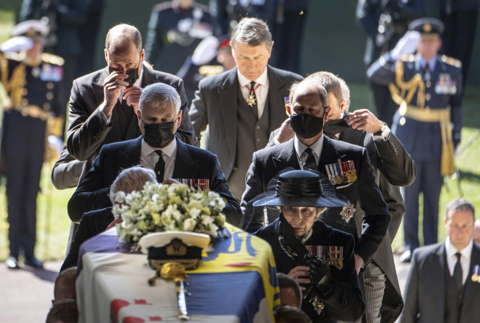 Pall Bearers carry the coffin of the Duke of Edinburgh into St George's Chapel for his funeral, as members of the royal family including Princess Anne, right, Prince Andrew, Prince Edward, Prince William and Sir Tim Laurence follow, at Windsor Castle, in Windsor, England, Saturday April 17, 2021. Prince Philip died April 9 at the age of 99 after 73 years of marriage to Britain's Queen Elizabeth II. (Danny Lawson/Pool via AP)