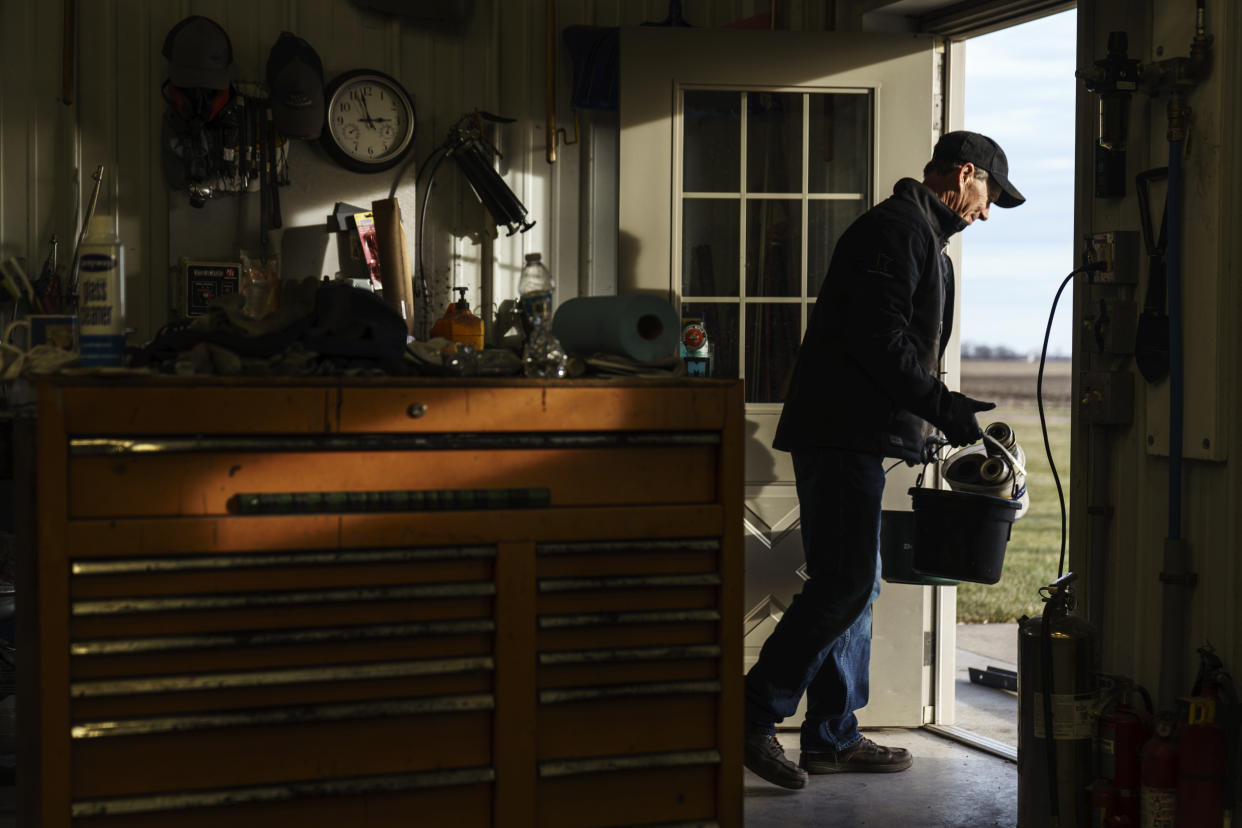 Al Saunders walks out of his farm's tool shed in Benson, Minn., Wednesday, Dec. 1, 2021. "I just can't stomach it anymore," said Saunders, whose family settled on part of his sprawling farm more than a century ago. The editorials in his local newspaper, The Swift County Monitor-News, on farm subsidies and the occasional praise for Democratic politicians leave him fuming. "Trash gets thrown at you so many times and eventually you just give up." (AP Photo/David Goldman)