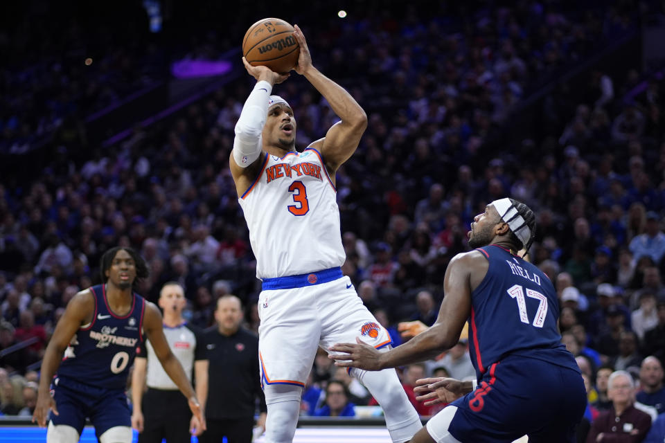 New York Knicks' Josh Hart (3) goes up for a shot against Philadelphia 76ers' Buddy Hield (17) during the first half of an NBA basketball game, Thursday, Feb. 22, 2024, in Philadelphia. (AP Photo/Matt Slocum)