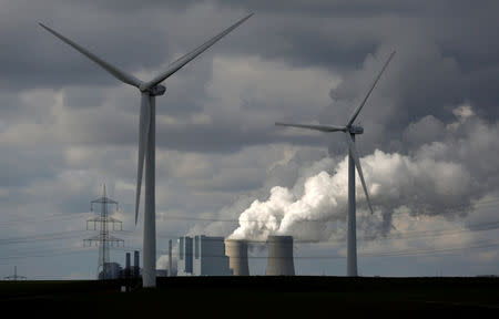 FILE PHOTO: Wind turbines are seen in front of a coal power plant of German utility RWE Power near the western town of Neurath February 28, 2014. REUTERS/Ina Fassbender/File Photo