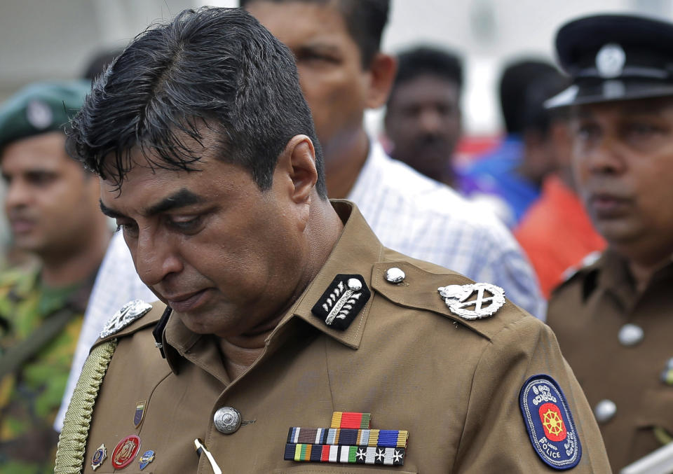 In this April 21, 2019 photo, Sri Lankan police chief Pujith Jayasundara leaves after an inspection at St. Anthony's church, one of the sites of Easter Sunday explosions in Colombo, Sri Lanka. Sri Lankan police on Tuesday arrested the country's police chief, currently on compulsory leave, and its former defense secretary for alleged negligence leading to the Easter Sunday bombings that killed more than 250 people at churches and hotels. (AP Photo/Eranga Jayawardena)