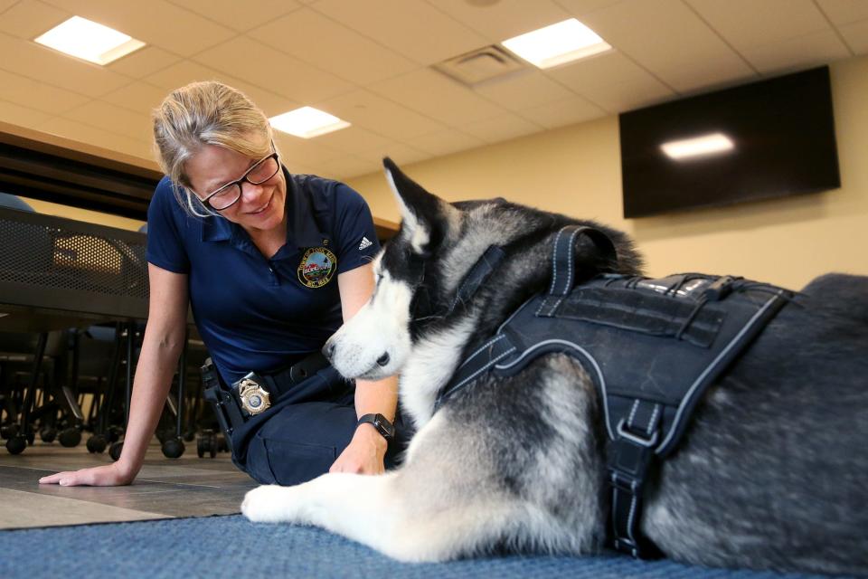 York police detective Jamie Robie pets comfort dog Yukon at the department Wednesday, Oct. 5, 2022.