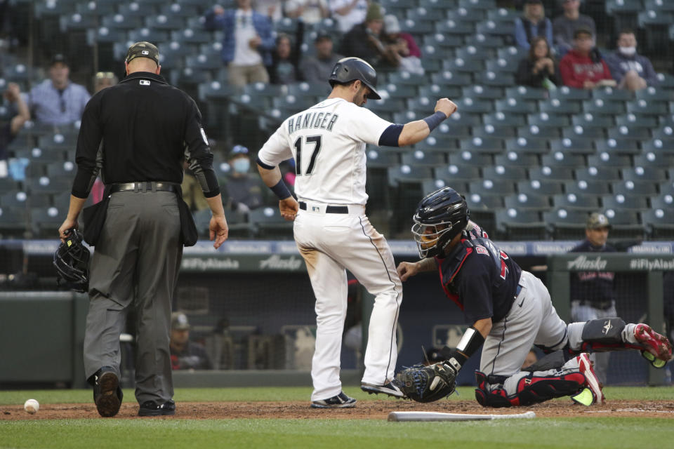 Seattle Mariners' Mitch Haniger is safe at home on a sacrifice fly by Jose Marmolejos as Cleveland Indians catcher Rene Rivera is unable to make the tag during the fifth inning of a baseball game Saturday, May 15, 2021, in Seattle. (AP Photo/Jason Redmond)