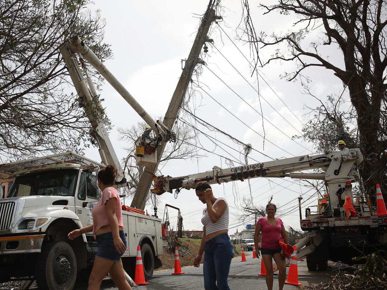An electrical crew attempts to repair power lines that were knocked over Hurricane Maria passed through on 27 September, 2017 in Corozal, Puerto Rico: Joe Raedle/Getty Images