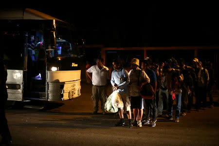 Central American migrants, part of a caravan moving through Mexico toward the U.S. border, stand in line before boarding a bus bound for Puebla, in Matias Romero, Mexico April 5, 2018. REUTERS/Edgard Garrido