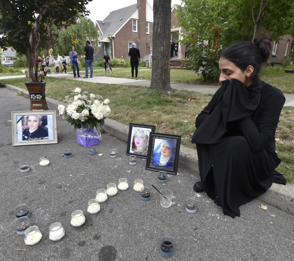 Zainab Aljanabi, sister of shooting victim Saja Aljanabi, puts her hands over her face as she cries at the makeshift memorial of her slain sister, Sunday, Sept. 8, 2019, as they light candles around her memorial in Dearborn, Mich. Dearborn Police Chief Ronald Haddad said Thursday, Sept. 12, 2019, that the 14-year-old, a 13-year-old and 17-year-old are being held in connection with last week's killing of Saja Aljanabi and they could be involved in other crimes in the area. (Todd McInturf/Detroit News via AP)