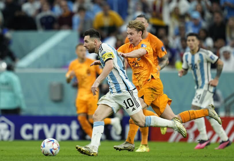 Argentina's Lionel Messi, front, duels for the ball with Frenkie de Jong of the Netherlands.
